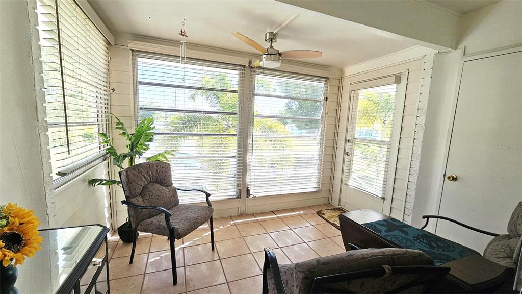 A sunroom with tiled floors, a ceiling fan, and large windows with horizontal blinds — 3586 CAPEHAZE DRIVE UNIT B4, ROTONDA WEST, FL