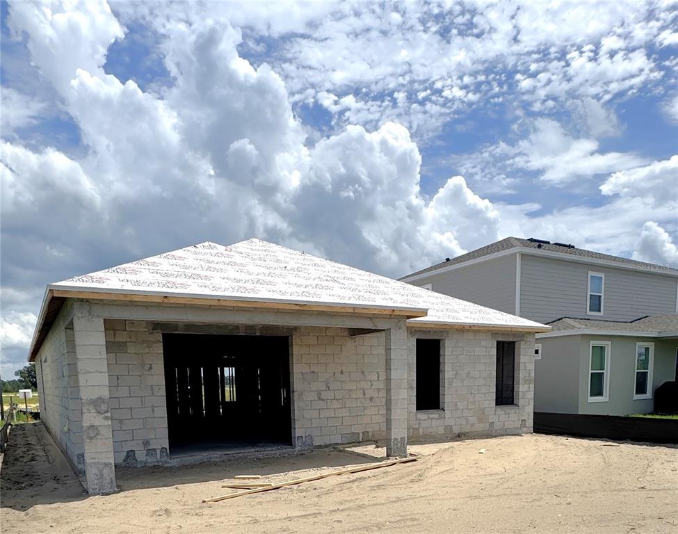 An exterior view of a single-story concrete block house under construction with a roof deck — 30273 RUSTIC MILL STREET, MOUNT DORA, FL