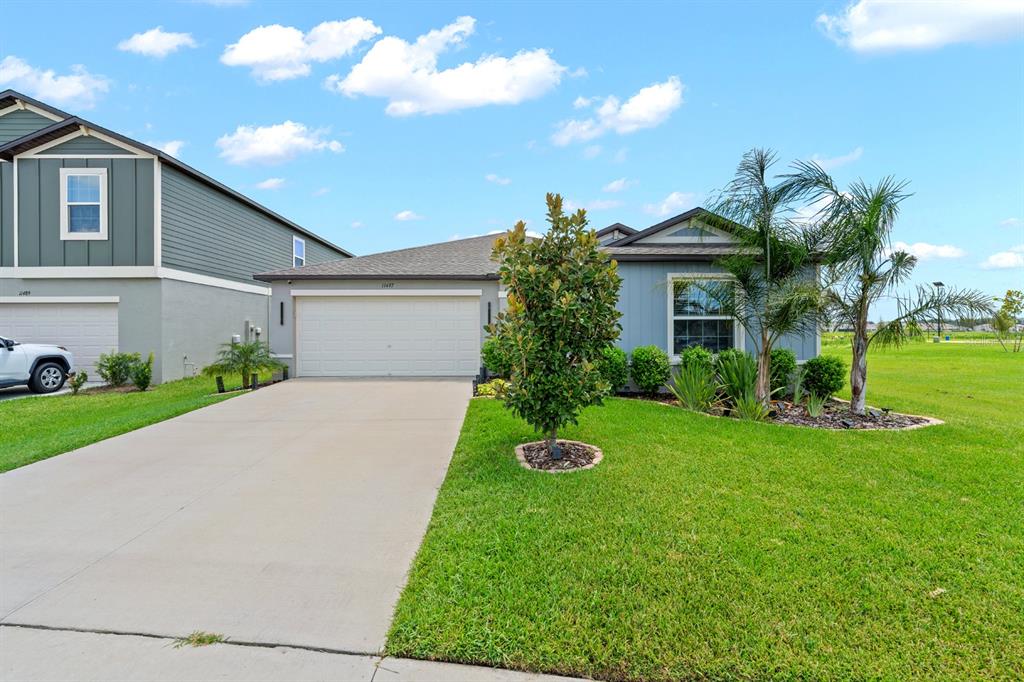 A single-story house with a two-car garage, gray siding, and a landscaped front yard — 11497 LINDEN DEPOT ROAD, SAN ANTONIO, FL