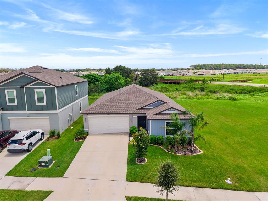 An aerial view shows a single-story house with a two-car garage next to a larger home — 11497 LINDEN DEPOT ROAD, SAN ANTONIO, FL