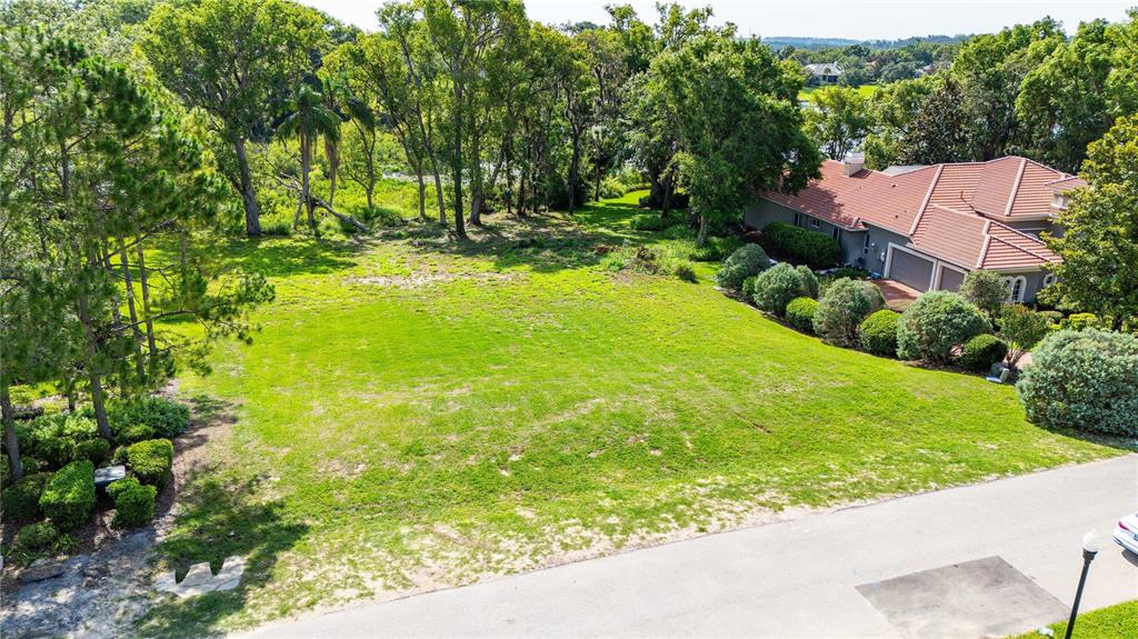 An elevated view shows a vacant grassy lot next to a house with a tiled roof — 12920 VENTANA CT, DADE CITY, FL