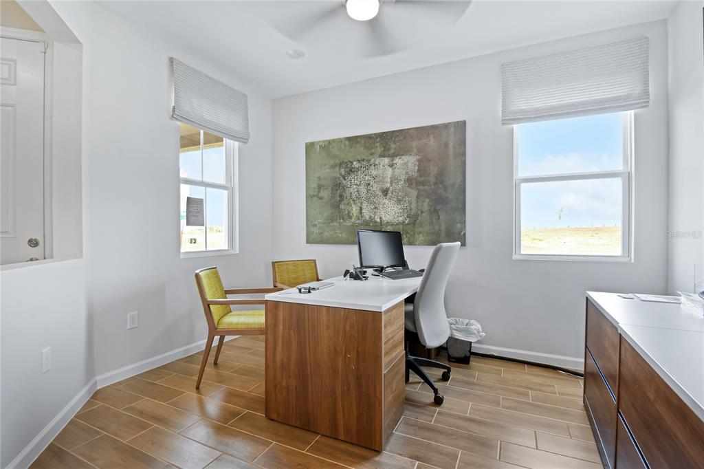A home office features a desk, two chairs, wood-look tile flooring, and two windows — 5314 SPRING MAIDEN CIRCLE, APOLLO BEACH, FL