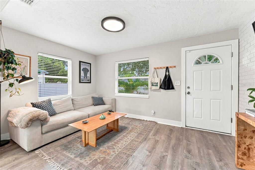 A living room features a light gray sofa, a wooden coffee table, and a white door — 4819 20TH STREET N, ST PETERSBURG, FL