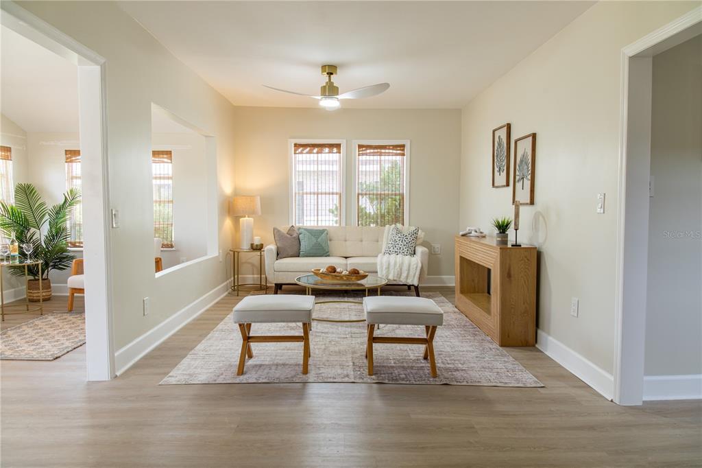 A living room features a sofa, two ottomans, a coffee table, and a wooden console — 13148 3RD STREET E, MADEIRA BEACH, FL