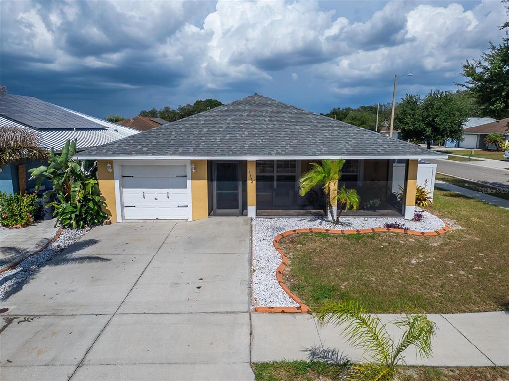 A single-story house with a white garage, a screened-in porch, and a concrete driveway — 15428 FLORIDA BREEZE LOOP, WIMAUMA, FL