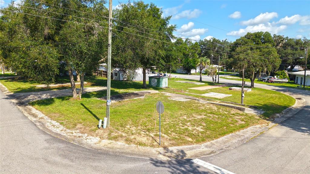 An aerial view shows a corner lot with concrete pads, trees, and utility poles — 3540 E BUFFALO LANE, HERNANDO, FL