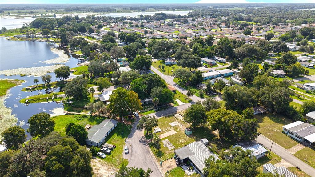 An aerial view shows a residential neighborhood with houses situated along a lakefront — 3540 E BUFFALO LANE, HERNANDO, FL