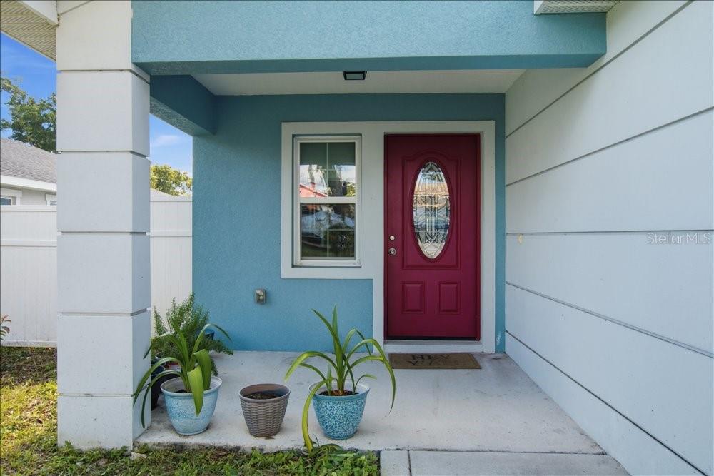 A single-story house features a red garage door, light blue siding, and a concrete driveway — 14584 20TH ST, DADE CITY, FL
