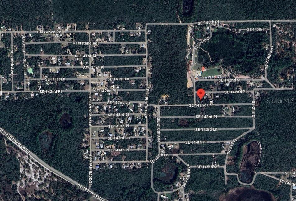 This is an aerial map showing a residential neighborhood with a red pin marking a property — 21175 SE 142ND LANE, UMATILLA, FL