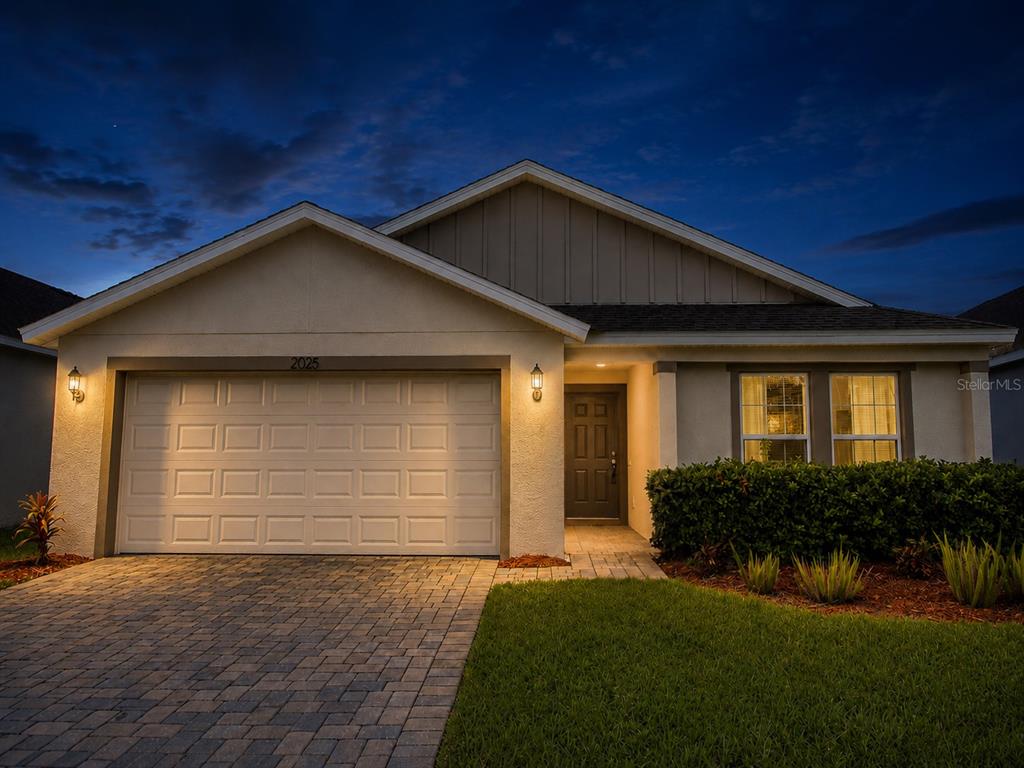 A single-story house with a paved driveway, a two-car garage, and a front entryway at dusk — 2025 HAVASU FALLS AVENUE, DELAND, FL