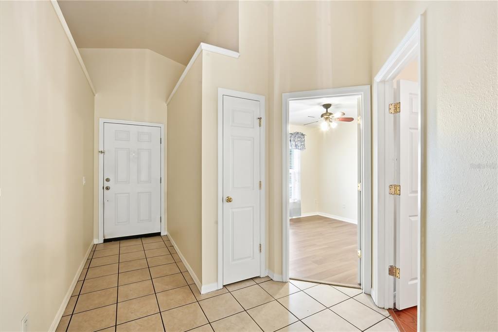 An entryway with tiled flooring, a white front door, and two interior doorways — 5246 MANGO FRUIT STREET, SEFFNER, FL