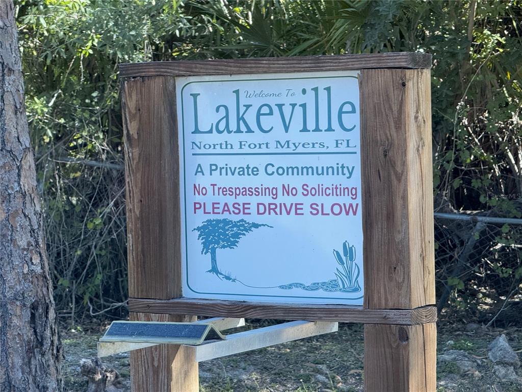 A wooden sign welcomes visitors to the private community of Lakeville in North Fort Myers — 2298 CHURCHILL LANE, NORTH FORT MYERS, FL