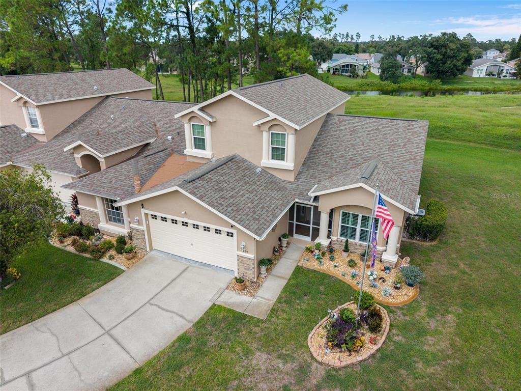 An aerial view shows a two-story suburban house with a garage and landscaped front yard — 7414 MOORGATE COURT, NEW PORT RICHEY, FL
