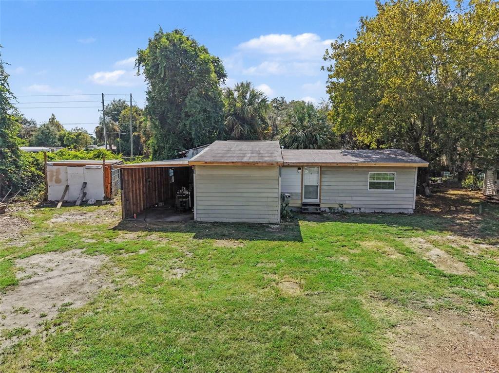 A single-story house with light-colored siding, a carport, and a detached shed in the yard — 4030 N LASSO TERRACE, HERNANDO, FL