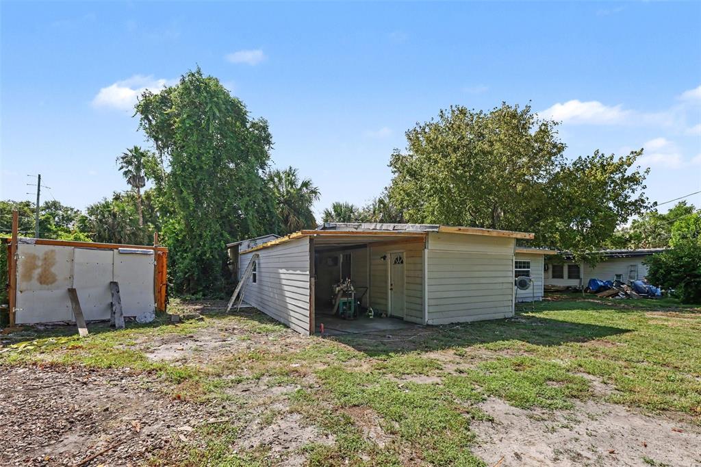 A light-colored mobile home with an attached carport sits on a grassy, partially dirt lot — 4030 N LASSO TERRACE, HERNANDO, FL