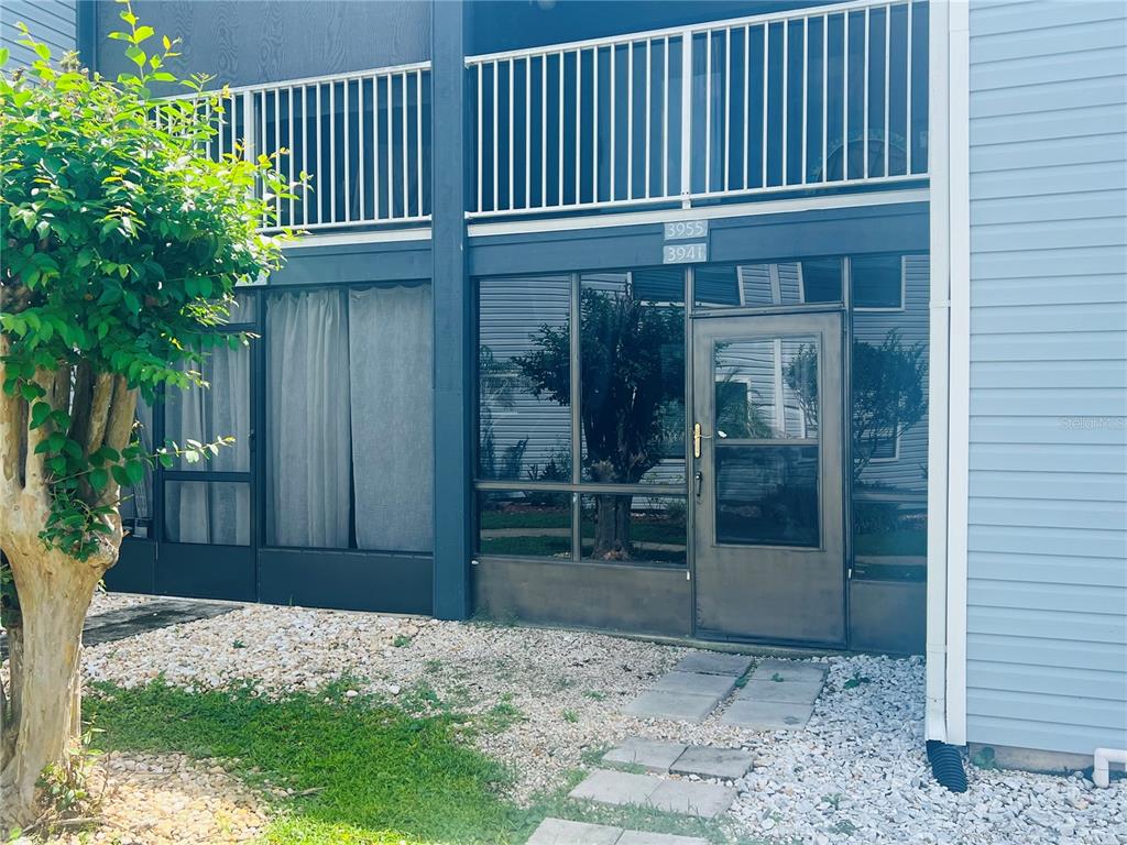 A landscaped yard features a tree, a concrete walkway, and a pond with a fountain — 3941 ATRIUM DRIVE UNIT L3, ORLANDO, FL