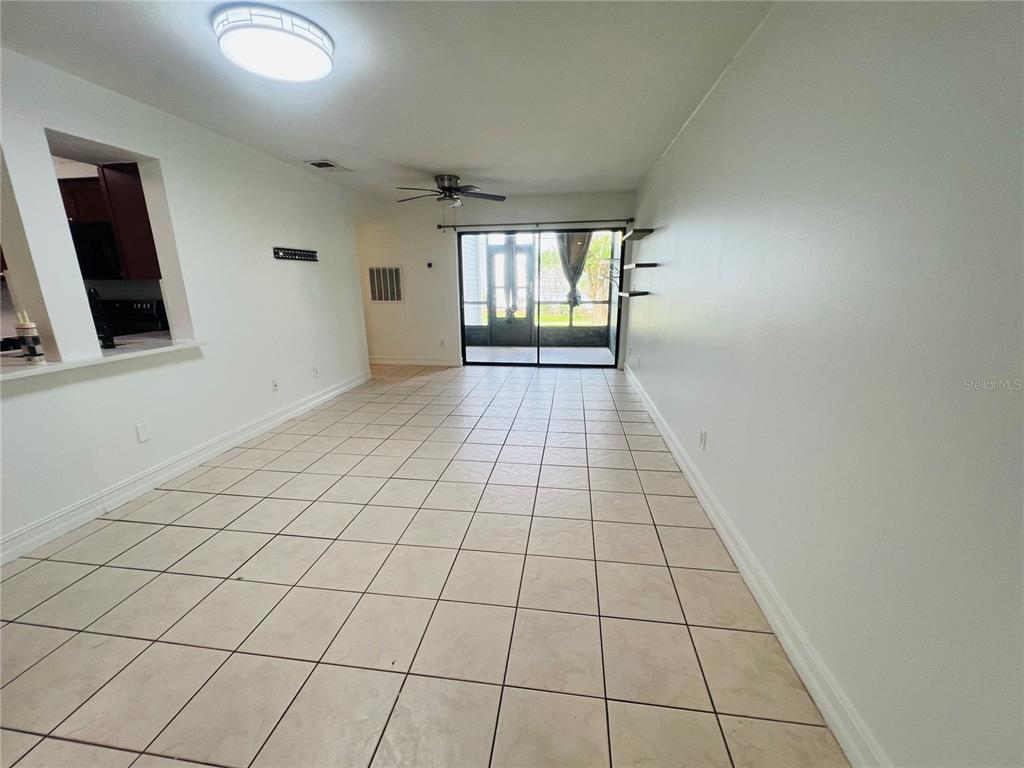 A kitchen with dark wood cabinets, stainless steel appliances, and a white countertop island — 3941 ATRIUM DRIVE UNIT L3, ORLANDO, FL