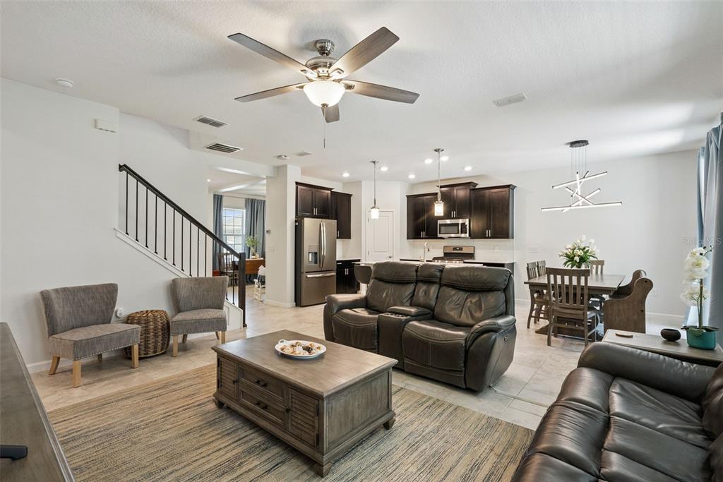 A living room features dark leather sofas, a wooden coffee table, and a wall-mounted television — 1235 DORA PARC LANE, MOUNT DORA, FL