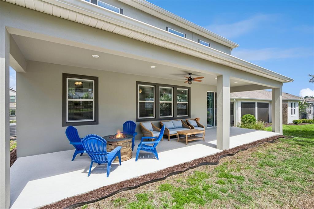 An open-concept living and dining area features dark cabinetry, tile flooring, and a ceiling fan — 1235 DORA PARC LANE, MOUNT DORA, FL