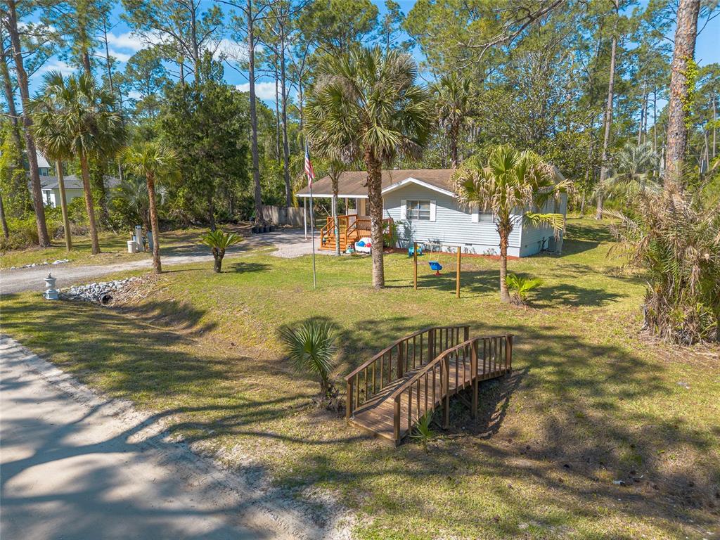 A single-story house with a carport, a wooden deck, and a paved driveway — 1650 11TH AVENUE, DELAND, FL