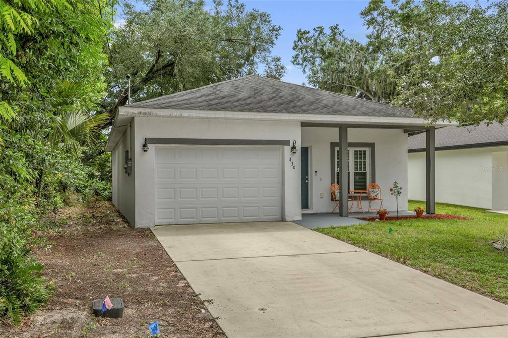A single-story house with a white exterior, a one-car garage, and a small front porch — 430 W WALTS AVENUE, DELAND, FL