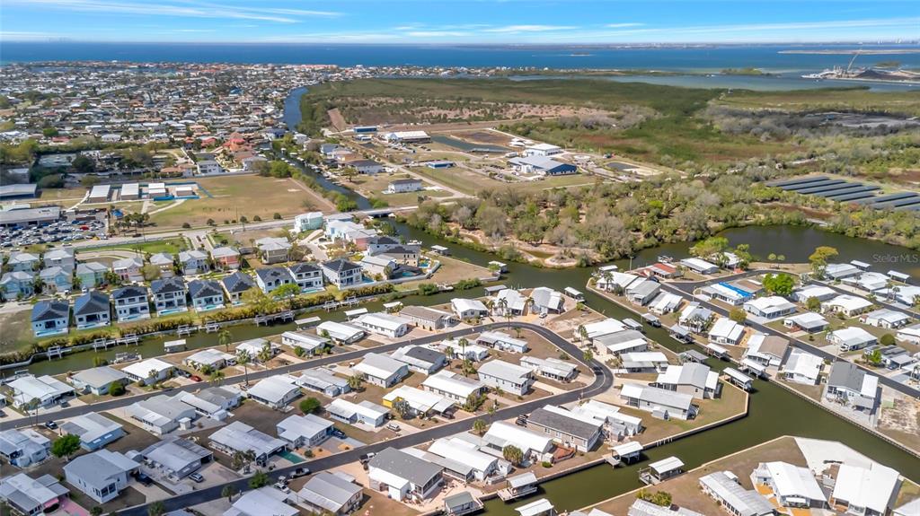 Aerial view of a waterfront residential neighborhood with canals and nearby undeveloped land — 110 E SAINT LUCIA LOOP, APOLLO BEACH, FL
