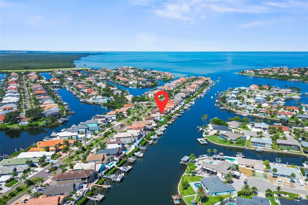 An aerial view shows a waterfront residential neighborhood with a red pin marking a house — 873 SYMPHONY ISLES BOULEVARD, APOLLO BEACH, FL