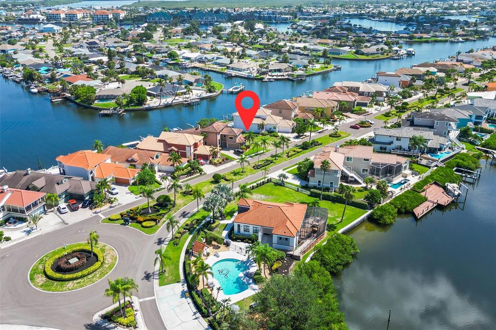 An aerial view shows a waterfront residential neighborhood with a red location pin on a house — 873 SYMPHONY ISLES BOULEVARD, APOLLO BEACH, FL