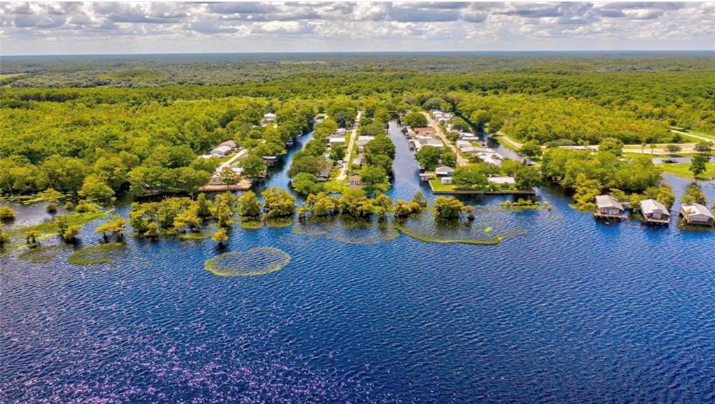 An aerial view shows waterfront homes situated along narrow canals surrounded by dense green forest — 21722 73RD LANE, VERO BEACH, FL