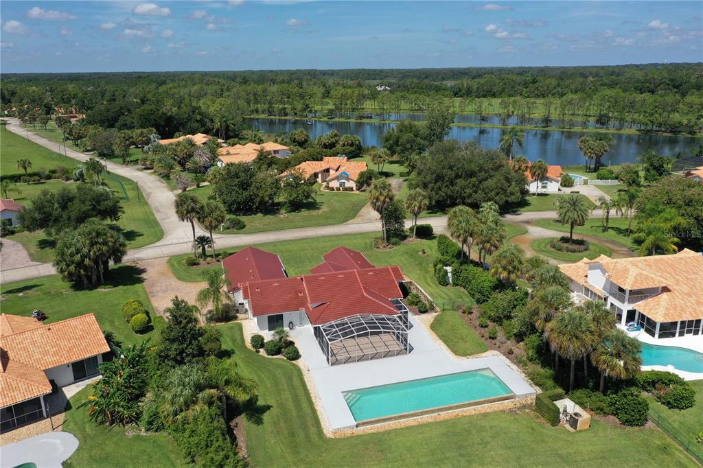 An aerial view shows a house with a red roof, pool, and patio in Florida — 13300 SKIING PARADISE BOULEVARD, CLERMONT, FL