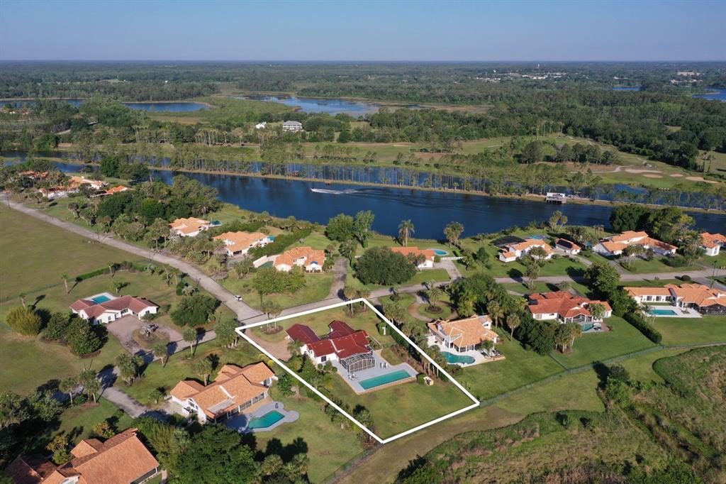 An aerial view of a house with a red roof, screened lanai, and rectangular pool — 13300 SKIING PARADISE BOULEVARD, CLERMONT, FL