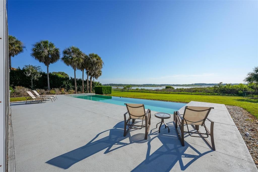 An aerial view shows three houses with swimming pools situated along a large lake — 13300 SKIING PARADISE BOULEVARD, CLERMONT, FL