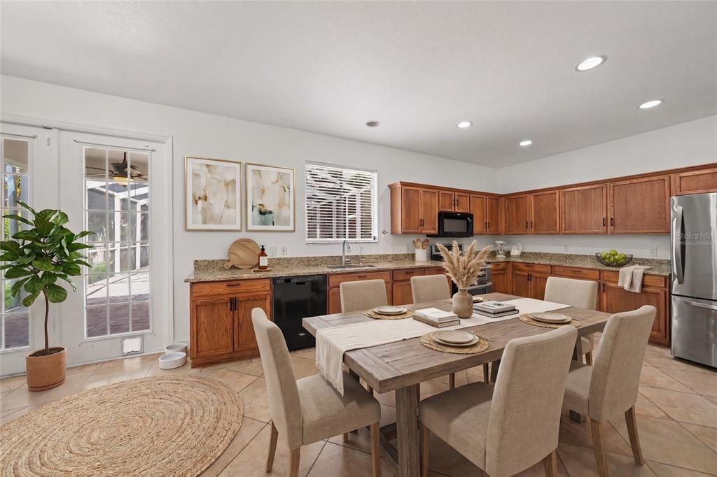 A two-story house with a beige stucco exterior, a two-car garage, and mature trees — 2436 SPRING HOLLOW LOOP, WESLEY CHAPEL, FL