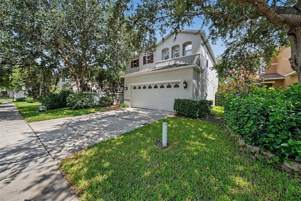 A view from a red front door into an open-concept living room with tiled floors — 2436 SPRING HOLLOW LOOP, WESLEY CHAPEL, FL