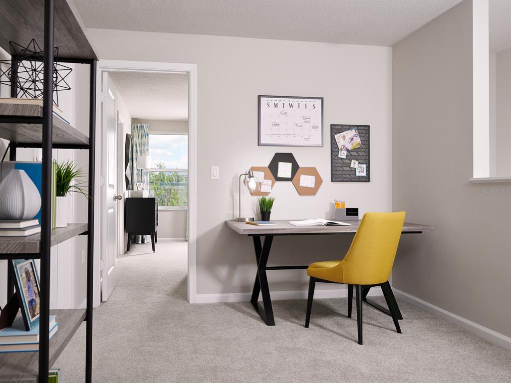 A home office features a desk, a yellow chair, wall decor, and a doorway view — 16258 BIRD OF PARADISE AVENUE, CLERMONT, FL