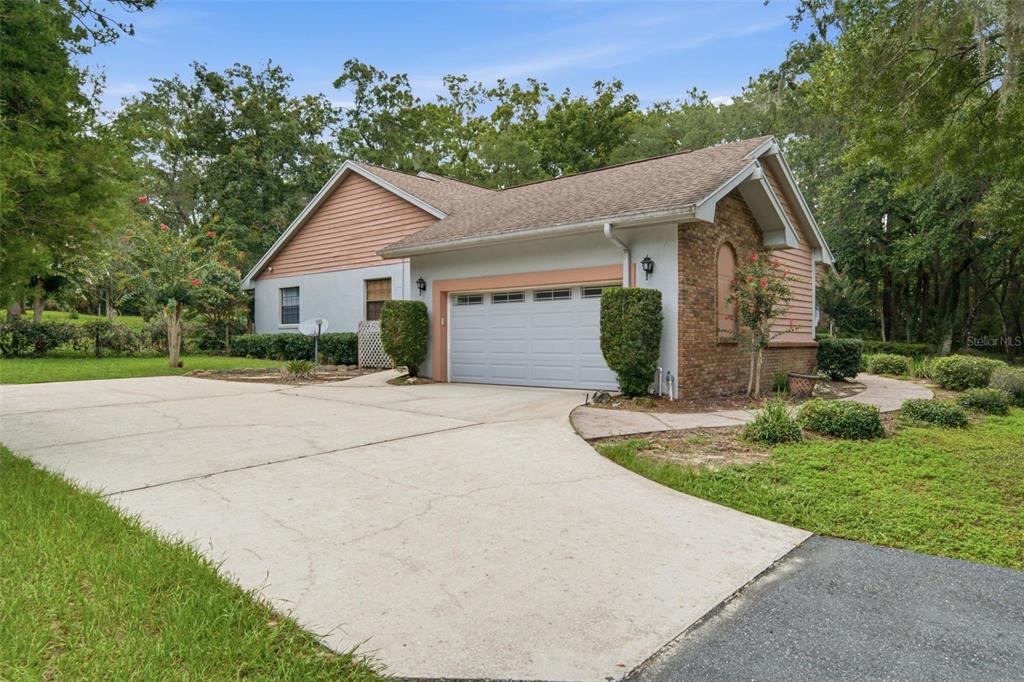 A single-story house with a two-car garage, brick accents, and a concrete driveway — 2705 W LIVE OAK STREET, LECANTO, FL