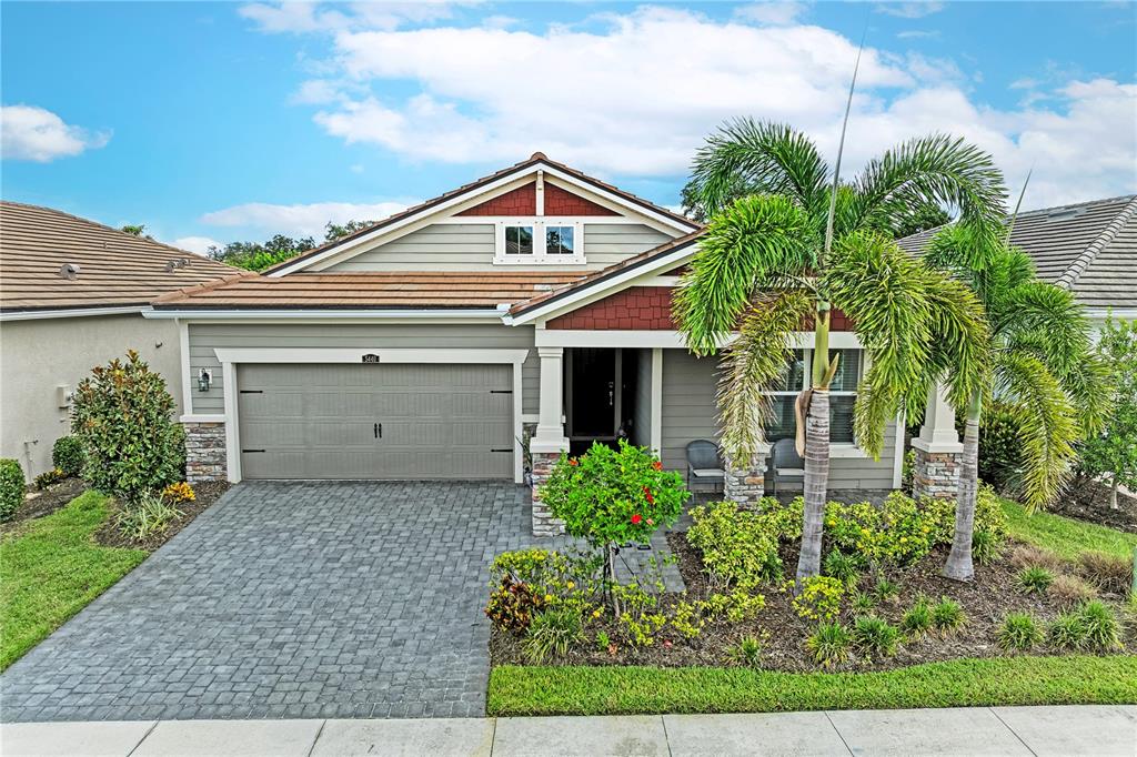 A single-story house with a gray garage, stone accents, and a palm tree in front — 5440 HOPE SOUND CIRCLE, SARASOTA, FL