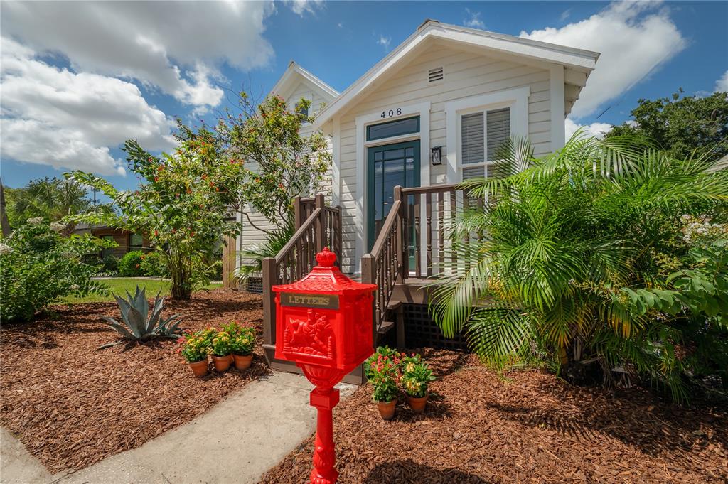 A bright red mailbox stands in front of a small house with a wooden porch — 408 E AMELIA AVENUE, TAMPA, FL
