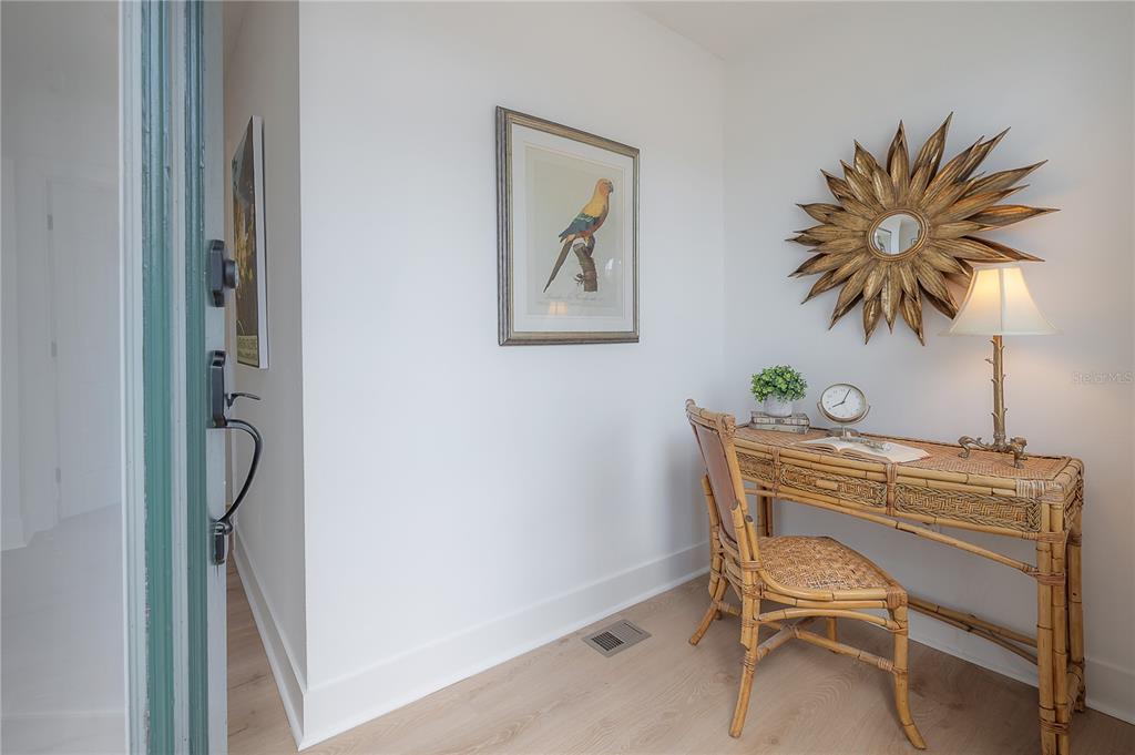A small home office area features a rattan desk, a matching chair, and a sunburst mirror — 408 E AMELIA AVENUE, TAMPA, FL