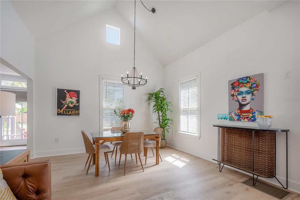 A bright dining room features a vaulted ceiling, a glass-topped table, and wicker chairs — 408 E AMELIA AVENUE, TAMPA, FL