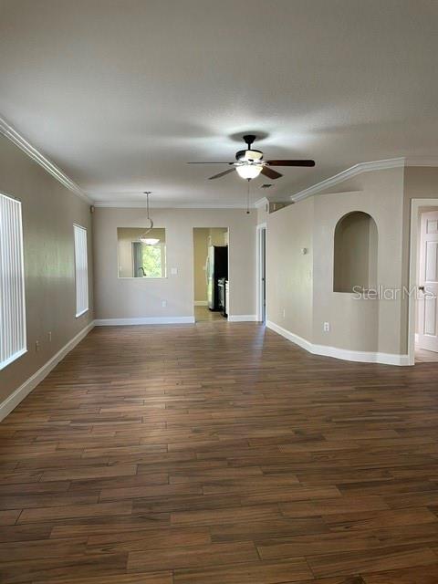 An open living area features wood-look tile flooring, a ceiling fan, and an arched wall niche — 2413 SAGEMONT DRIVE, BRANDON, FL