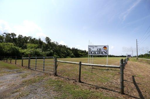 A fenced, grassy vacant lot features a sign for the future site of BeachWest — 00 OLD DIXIE HIGHWAY, HUDSON, FL