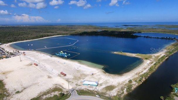 An aerial view shows a large lake with a sandy beach and an inflatable water park — 00 OLD DIXIE HIGHWAY, HUDSON, FL