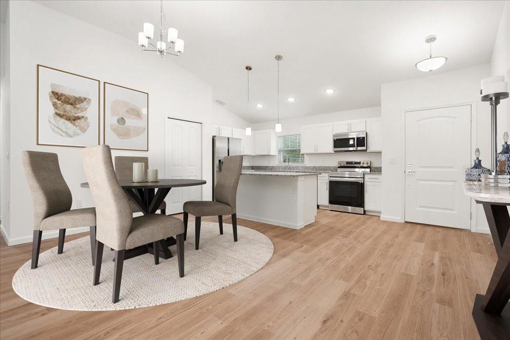 A dining area with a round table and chairs sits adjacent to an open kitchen — 23 WHITTINGTON DRIVE, PALM COAST, FL