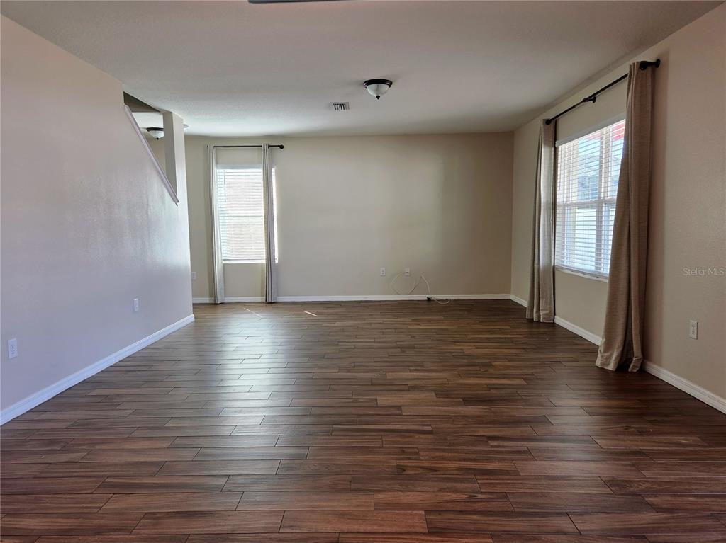 A dining room with wood-look flooring, a central pendant light, and a window with blinds — 109 TIERRA VERDE WAY, BRADENTON, FL
