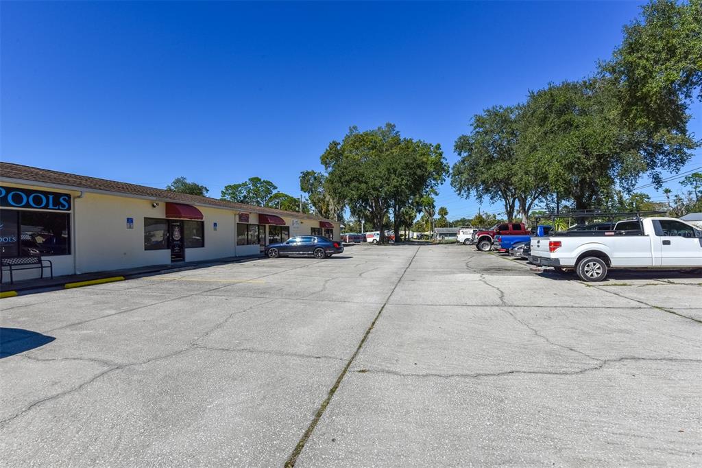 A commercial building with a parking lot and several parked vehicles under a clear sky — 703 S STATE STREET, BUNNELL, FL
