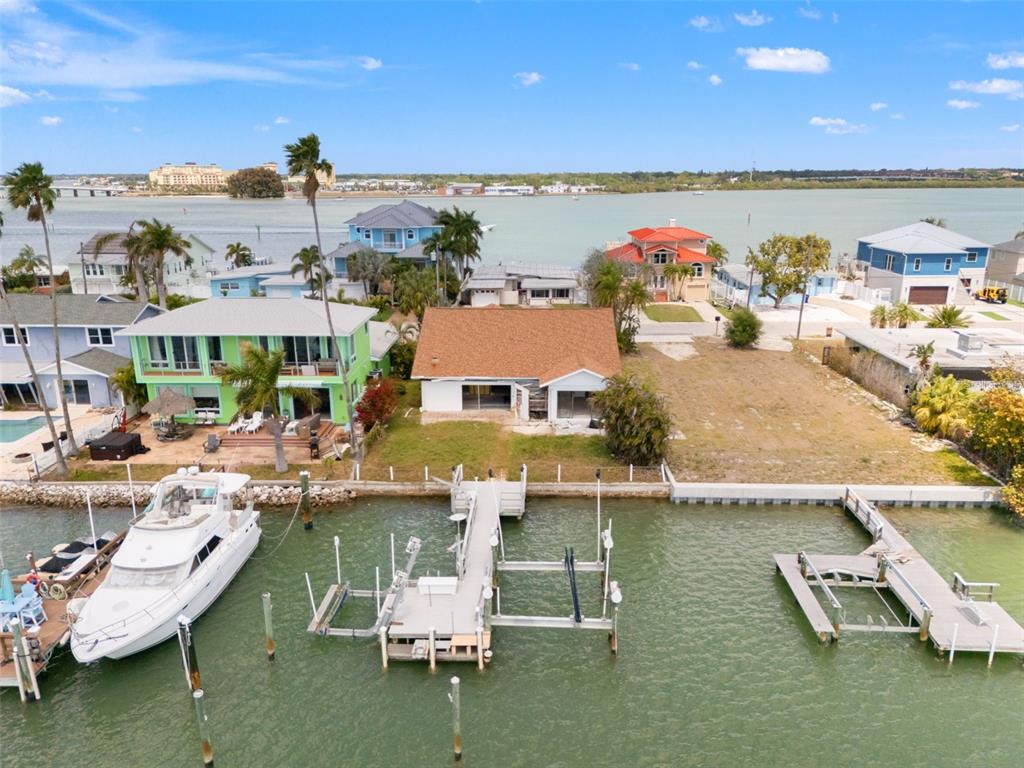 An aerial view of a waterfront house with a private dock and a boat — 811 BAY POINT DRIVE, MADEIRA BEACH, FL