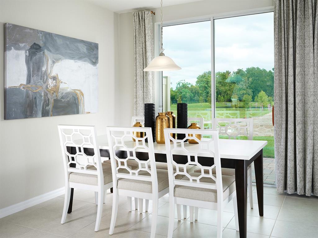 A dining room with a white table, geometric chairs, and a sliding door to a yard — 4539 RANGELAND WAY, ST CLOUD, FL