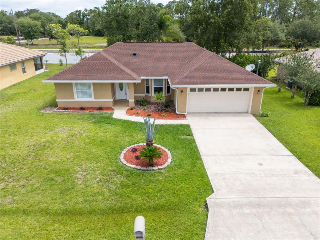 A living area with tile floors, a ceiling fan, and a central kitchen pass-through wall — 37 ROCKEFELLER DRIVE, PALM COAST, FL