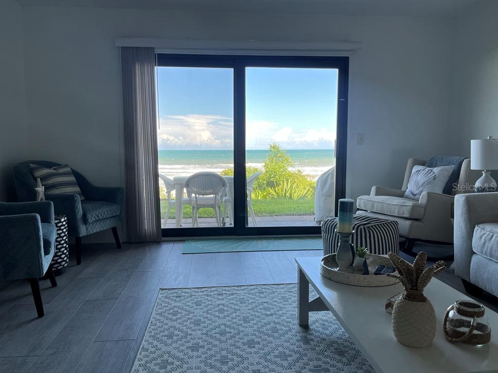 A living room features a sliding glass door with a direct view of the ocean — 8550 A1A #261 S UNIT 25161, ST AUGUSTINE, FL